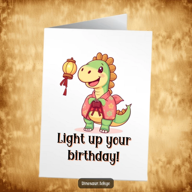 Funny free printable birthday card of a joyful dinosaur in a vibrant kimono holding a glowing lantern aloft.